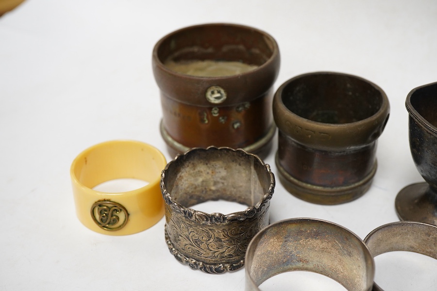 Four assorted silver napkin rings, an Indian white metal napkin ring, a small silver egg cup and four other items.